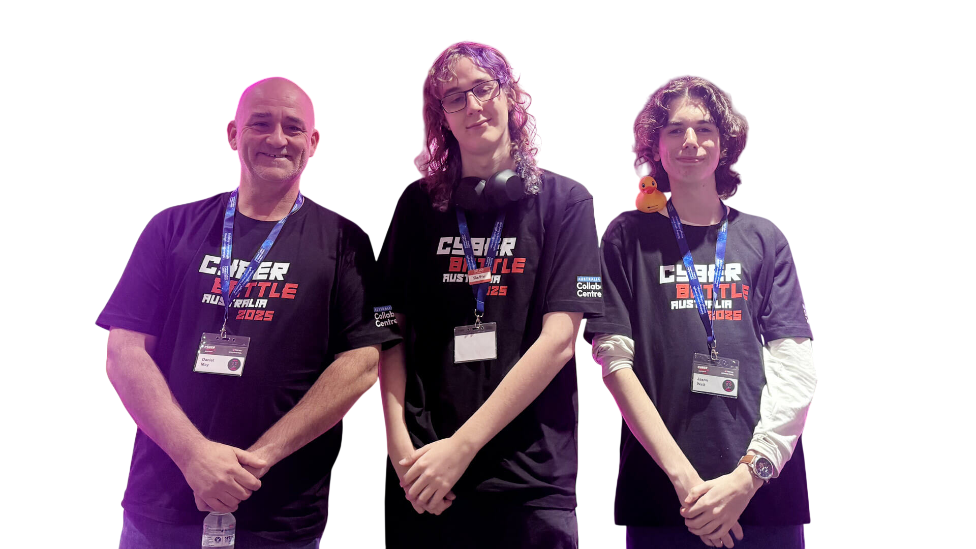 Three members of the TAFE Queensland team in Cyber Battle Australia 2025 shirts, under magenta light at the Grand Final venue. Jaxon Watt is on the right.